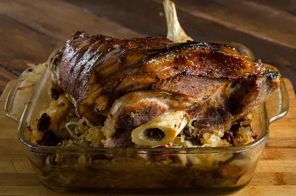 Gebratene Schweinshaxe mit geschmorten Sauerkrautwürstchen auf einem Holz — Stockfoto
