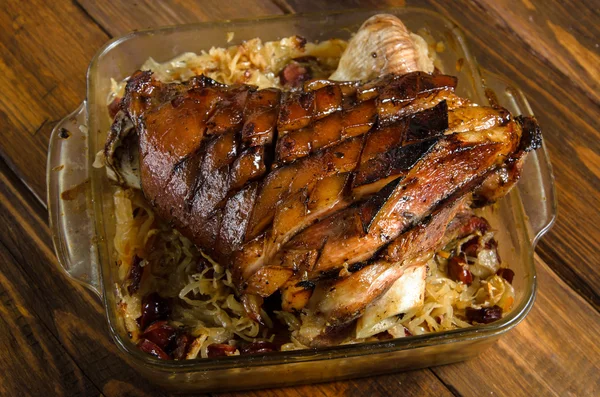 Kavrulmuş domuz knuckle bir ahşap üzerine kızarmış lahana turşusu sosis ile