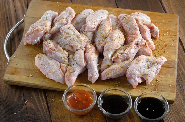 Rohe Chicken Wings mit Soßen auf Holz — Stockfoto