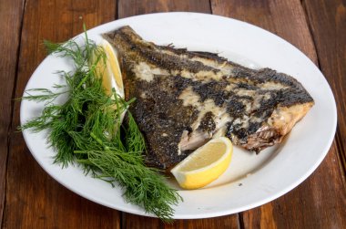 Beyaz plaka üzerinde ızgara pisi balığı