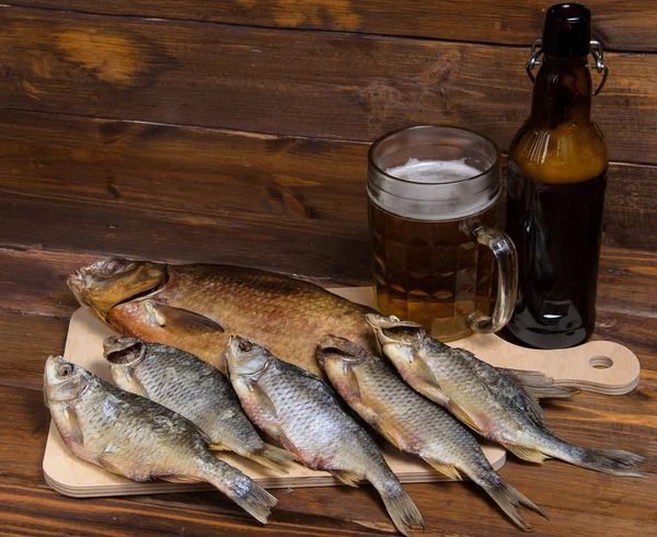 Peixe seco em fundo de madeira com cerveja — Fotografia de Stock