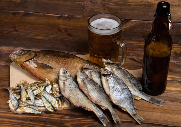 Peixe seco em fundo de madeira com cerveja — Fotografia de Stock