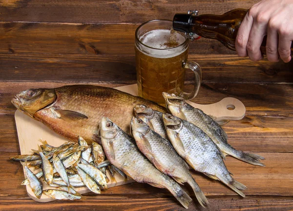 Peixe seco em fundo de madeira com cerveja — Fotografia de Stock