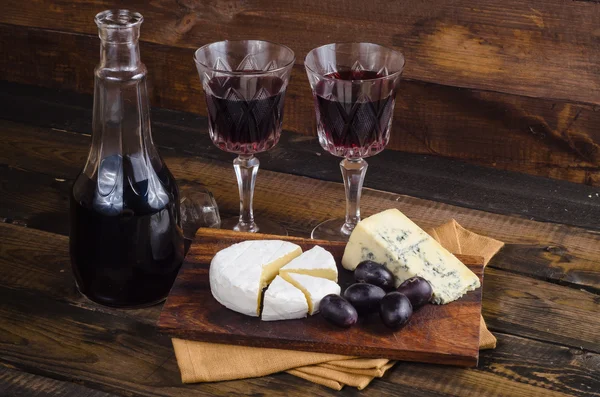 Сирна тарілка з виноградом та вином на дереві — стокове фото