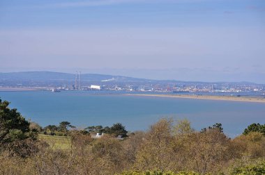 Havaya benzeyen güzel manzaralı ağaçlar, İrlanda denizi, körfez, Dublin Enerji Atıkları (Covanta Santrali), Poolbeg CCGT, Güvercin Evi Enerji İstasyonu, Dublin Dağları Howth, Dublin, İrlanda 'da görüldü.
