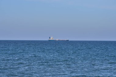 İrlanda Denizi 'nde Dun Laoghaire Limanı, Dublin, İrlanda' nın Batı İskelesi 'nden görülen güzel bir kargo gemisi akşam manzarası. Yumuşak ve seçici odaklanma. Minimalizm
