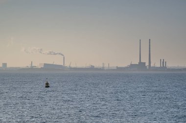 Dublin Atık Enerji Santrali 'nin (Covanta Santrali) güzel puslu akşam manzarası, Dun Laoghaire limanı Dublin, İrlanda' dan Poolbeg CCGT ve Pigeon House Power Station manzarası. Yumuşak ve seçici odak