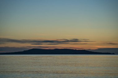 İrlanda, Dublin 'deki Blackrock Sahili' nden Howth 'ın güzel sabah manzarası. Yumuşak ve seçici odaklanma. Sunrise Marine temalı. Ada siluetleri