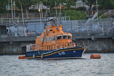 Dublin, İrlanda - 21 Haziran 2021: Dun Laoghaire limanındaki turuncu ve mavi filikaların güzel akşam manzarası. Dun Laoghaire Filika İstasyonu. Yumuşak ve seçici odak