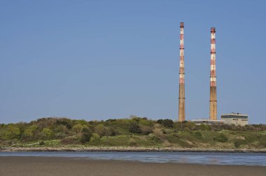 Dublin, İrlanda 'daki Sandymount Plajı' ndan görülen açık mavi gökyüzü karşısında ikonik Havuz Yalvarma İstasyonu bacalarının güzel yakın görüntüsü. Yumuşak renkler. Boşluğu kopyala