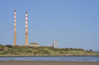 Sandymount Beach, Dublin 'den görünen temiz mavi gökyüzü karşısında ikonik Havuz Dilenci güç istasyonu bacalarının ve Havuz dilencisi CCGT istasyonunun güzel yakın görüntüsü. Yumuşak renkler. Boşluğu kopyala
