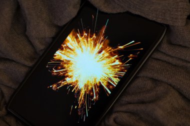 Arka plan olarak bir maytap var bir smartphone yeni yıl konseptiyle