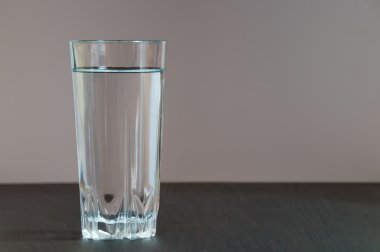 Temiz suda uzun boylu bir bardakla