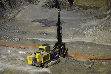 Sarı bir sanayi makinesi üzerinde bir taş ocağı çalışma