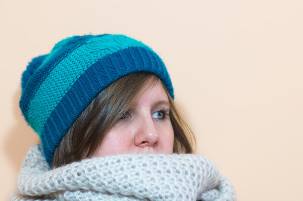 Девочка смотрит направо, а она в пушистом шарфе и голубом платке.
