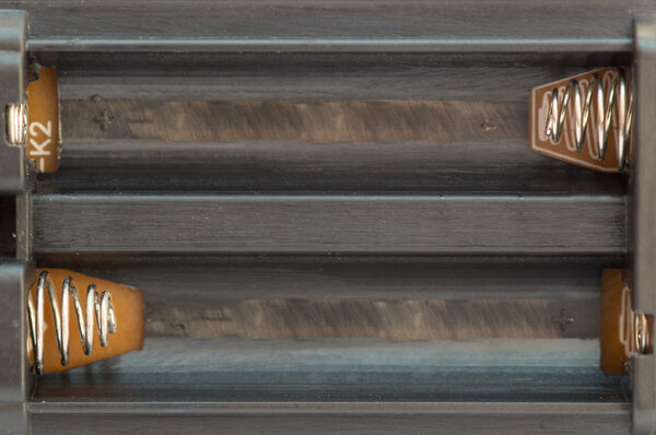 Верхний вид черного пластикового аккумулятора с металлическими разъемами
