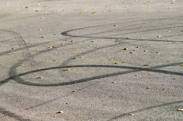 Skid marks on the asphalt with yellow leaves — Stock Photo, Image