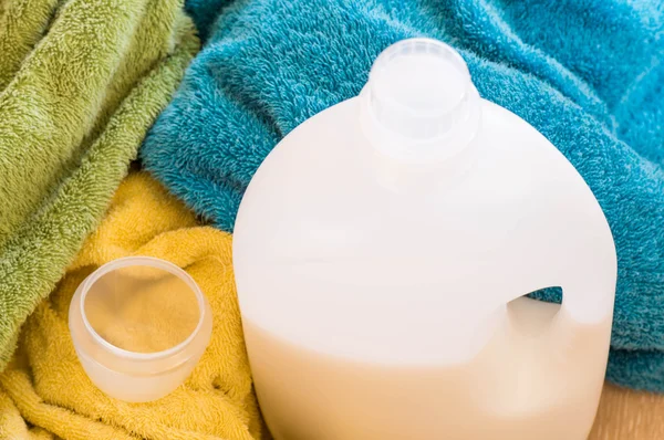 Bottle of liquid detergents with measuring cup — Stock Photo, Image