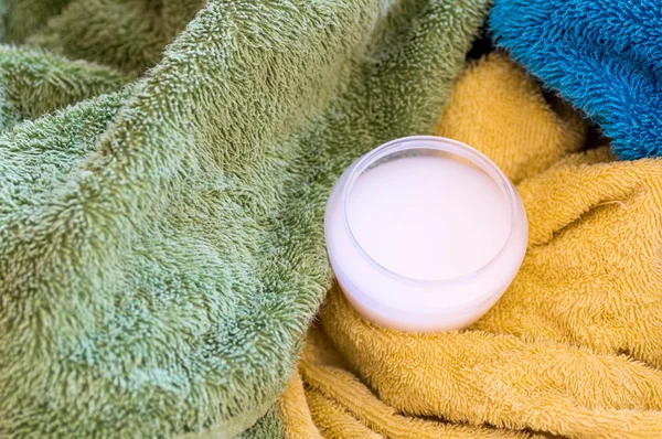 Filled measuring cup with liquid detergents on towels — Stock Photo, Image