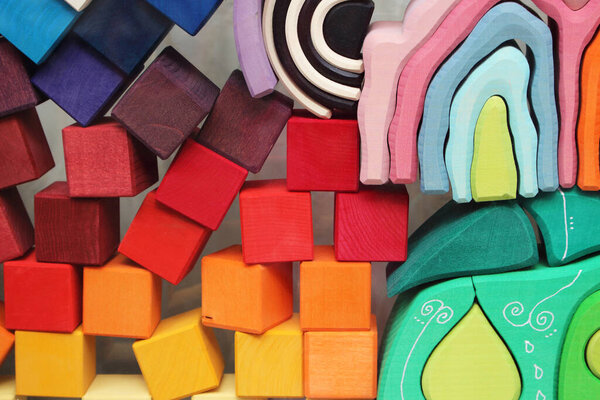 Balancing wooden play blocks. Colorful children's play blocks in all the colors of the rainbow. Red, yellow, blue, green, orange, pink, black, white, light blue, light green, purple