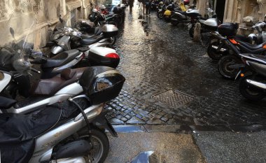 Roma, İtalya - 8 Mart 2016 - Yağmur altında park etmiş scooterlarla dolu bir ara sokak. Roma 'nın merkezinde