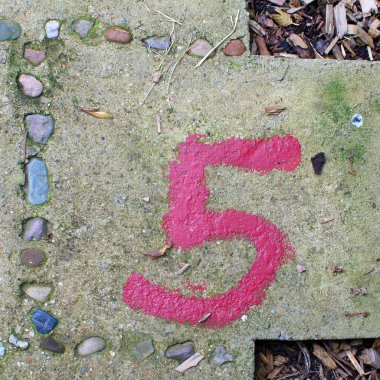 Beş numara gri betona kırmızı boya ile boyanmış. Betondan yapılmış seksek oyununun bir parçası.