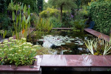 Loozen, Hollanda - 17 Ağustos 2021 Ada Hofman 'ın gölet bahçesinde bir geometrik gölet. Ada Hofman 1987 'de ilham verici bahçe kompleksini yarattı. Bütün göletleri ekolojik temelde..