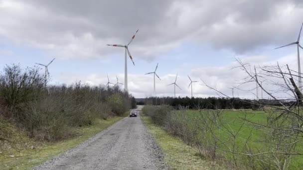 Wilsum Lower Saxony Germany 2021年3月17日一辆无声驾驶的黑色和红色电动车 智能Eq四电动驱动 第二代 远处是旋转的风力涡轮机 带着声音 — 图库视频影像