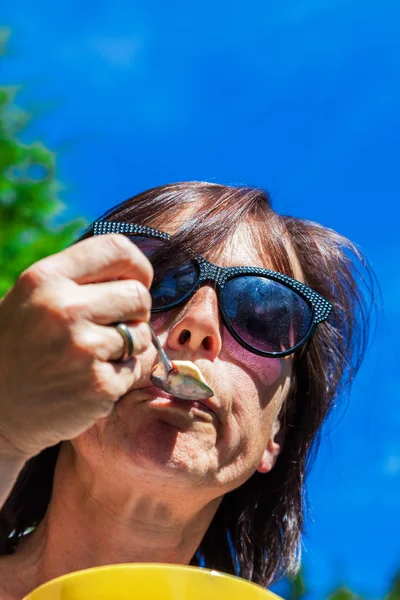 Жінка в сонцезахисних окулярах їсть лід — стокове фото