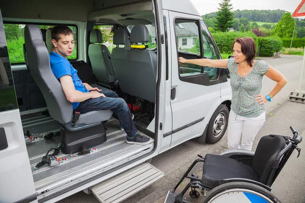 Osób niepełnosprawnych chłopiec jest odbierane przez Autobus szkolny — Zdjęcie stockowe