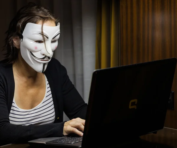 Pattaya, Thailand 17 November 2015: Seorang wanita dengan topeng Vendetta di depan laptop. Topeng ini adalah simbol terkenal untuk kelompok hacktivist online Anonymous. Juga digunakan oleh pengunjuk rasa . — Stok Foto