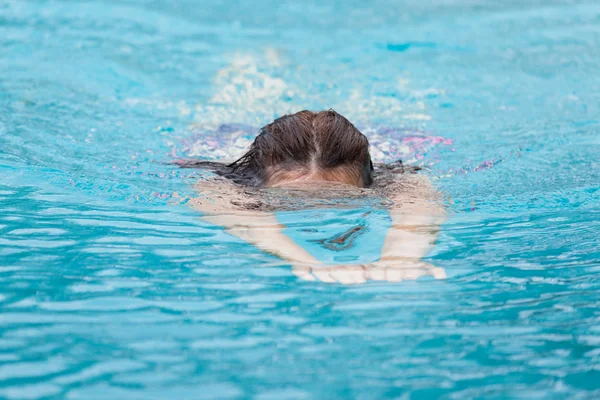 Una mujer mientras nada, cabeza de buceo justo debajo del agua — Foto de Stock