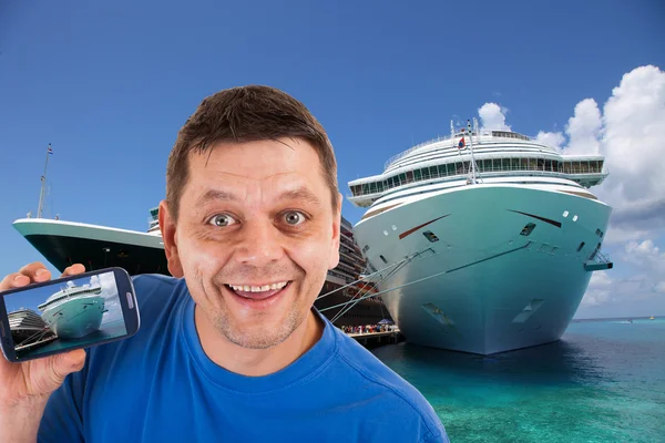 Man in front of two cruise ships with photos precisely this on his mobile phone — Stock Photo, Image