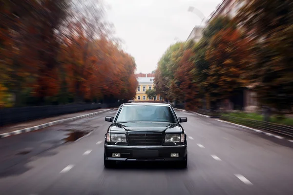 Vitesse de la voiture noire sur la route asphaltée en ville le jour — Photo