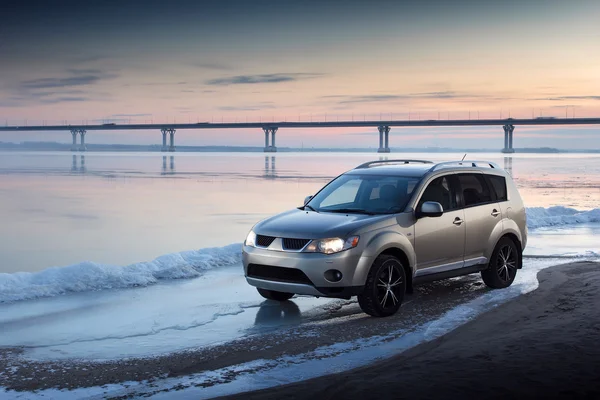 Car stay on ice coast at winter sunset — Stock Photo, Image