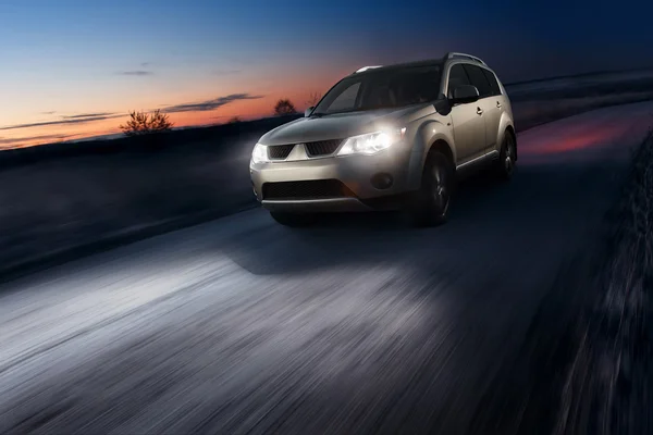 Alacakaranlıkta asfalt yolda araba hızlı hızlı sürücü