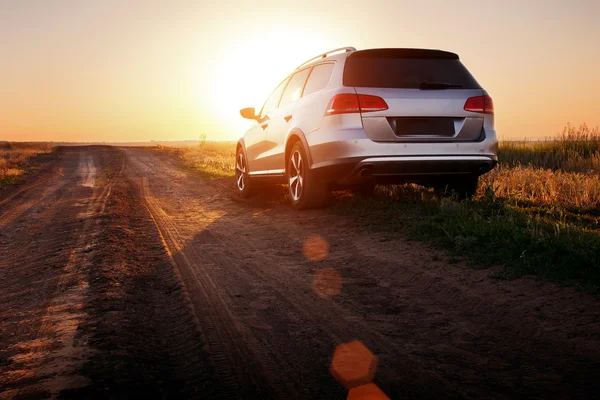 Šedá auto pobyt na polní cestě při západu slunce — Stock fotografie