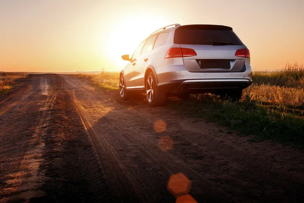 Gris coche estancia en camino de tierra al atardecer — Foto de Stock