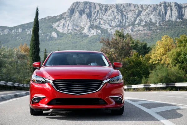 Voiture rouge debout sur la route près des montagnes le jour — Photo