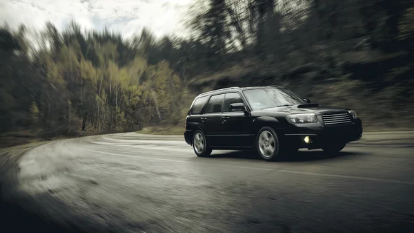 Black car fast drive on asphalt road at daytime — Stock Photo, Image