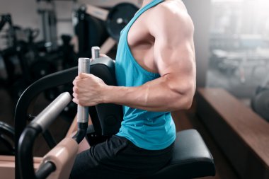 Spor salonunda fitness makinede çalışan adam