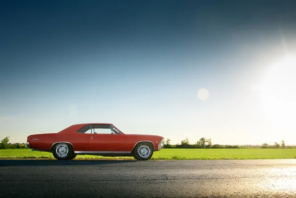 Retro red car Chevrolet Malibu stay on asphalt road at sunset — Stock Photo, Image