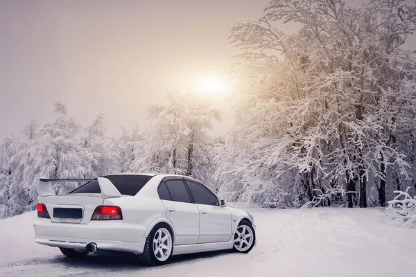 Vit bil Mitsubishi Galant Vr-4 på landsbygden vägen på vintern sunset — Stockfoto