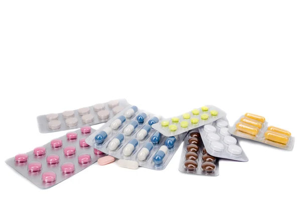 Медичні таблетки та капсули на білому тлі — стокове фото
