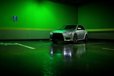 Gri araba Mitsubishi Lancer yeraltı park yerinde kal ve ıslak asfalt yansıtacak