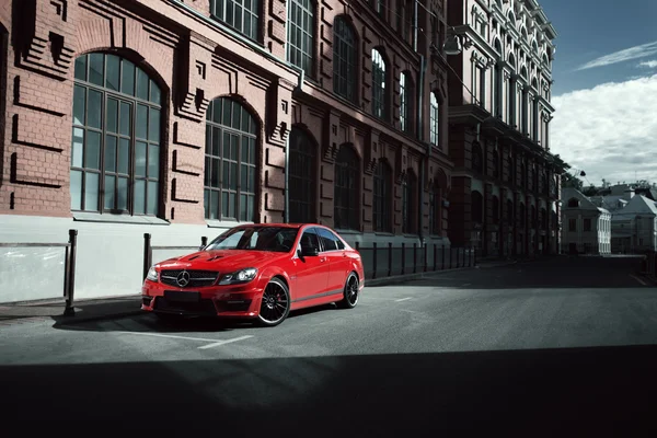 Carro vermelho Mercedes-Benz C63 AMG ficar na estrada de asfalto na cidade de Moscou durante o dia — Fotografia de Stock