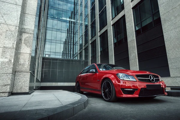 El coche rojo Mercedes-Benz C63 AMG se queda en la carretera de asfalto en la ciudad de Moscú durante el día —  Fotos de Stock