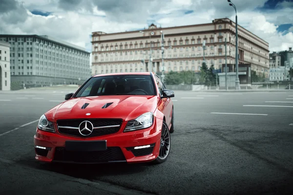 El coche rojo Mercedes-Benz C63 AMG se queda en la carretera de asfalto en la ciudad de Moscú durante el día — Foto de Stock