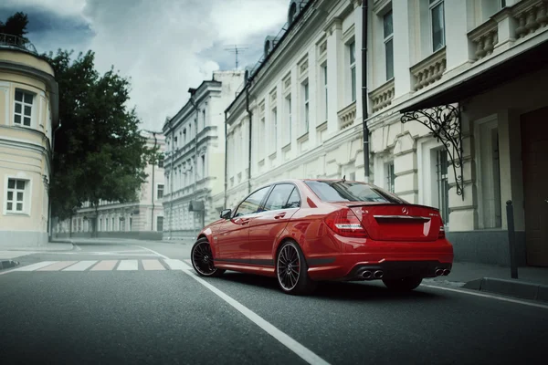 Rød bil Mercedes-Benz C63 AMG holder seg på asfaltvei i byen Moskva på dagtid – stockfoto