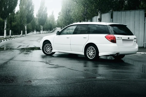Car Subaru Legacy stay on asphalt road and reflected in puddle in the city at daytime — Stock Photo, Image